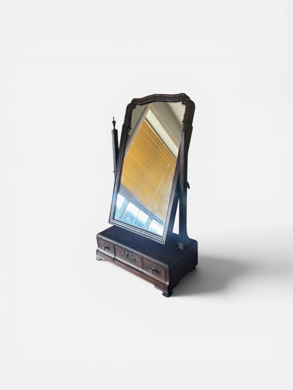 A George III mahogany toilet mirror featuring an adjustable swing plate mounted above a plinth base with three drawers and brass hardware. View II