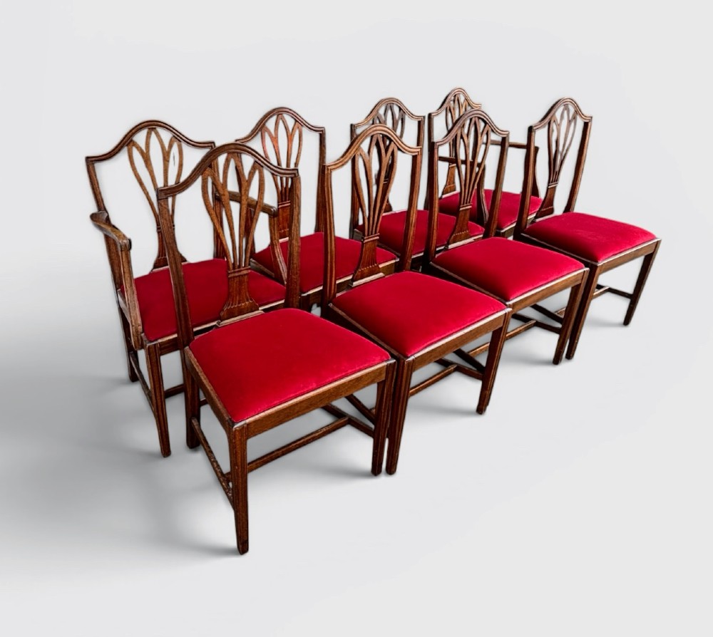 A set of eight George III mahogany dining chairs featuring carved wheat sheaf back splats and red velvet seats. View III