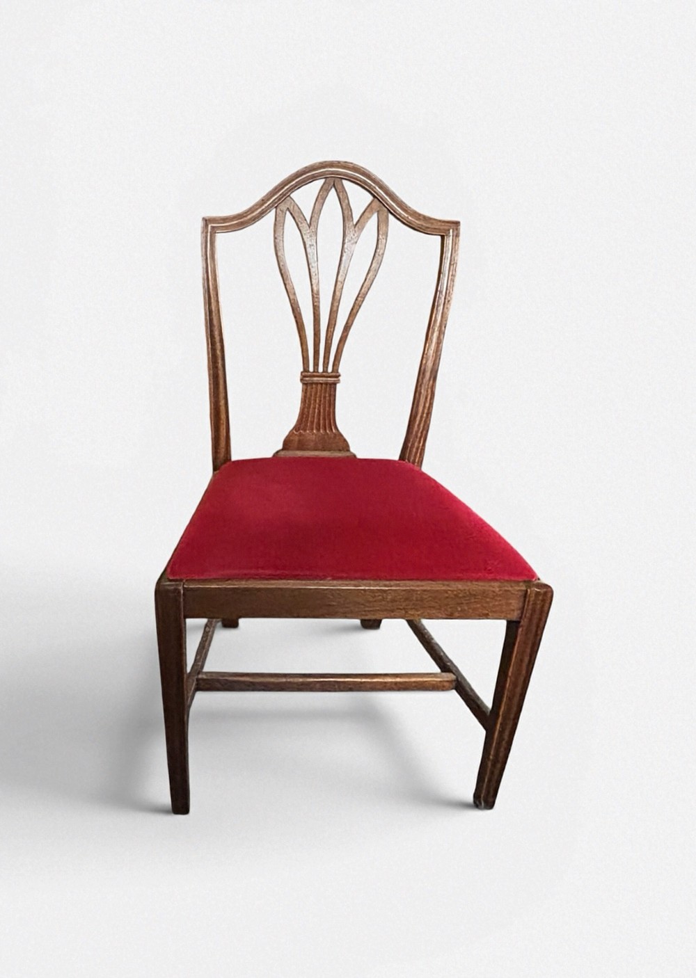 A set of eight George III mahogany dining chairs featuring carved wheat sheaf back splats and red velvet seats. View IV