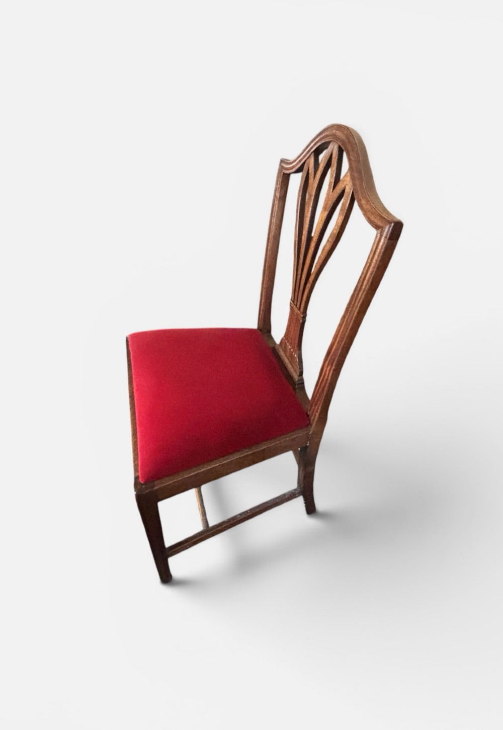 A set of eight George III mahogany dining chairs featuring carved wheat sheaf back splats and red velvet seats. View V