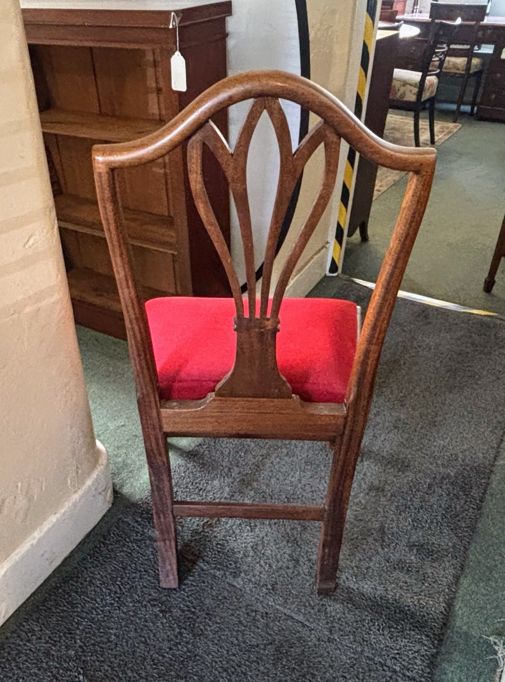 A set of eight George III mahogany dining chairs featuring carved wheat sheaf back splats and red velvet seats. View IX