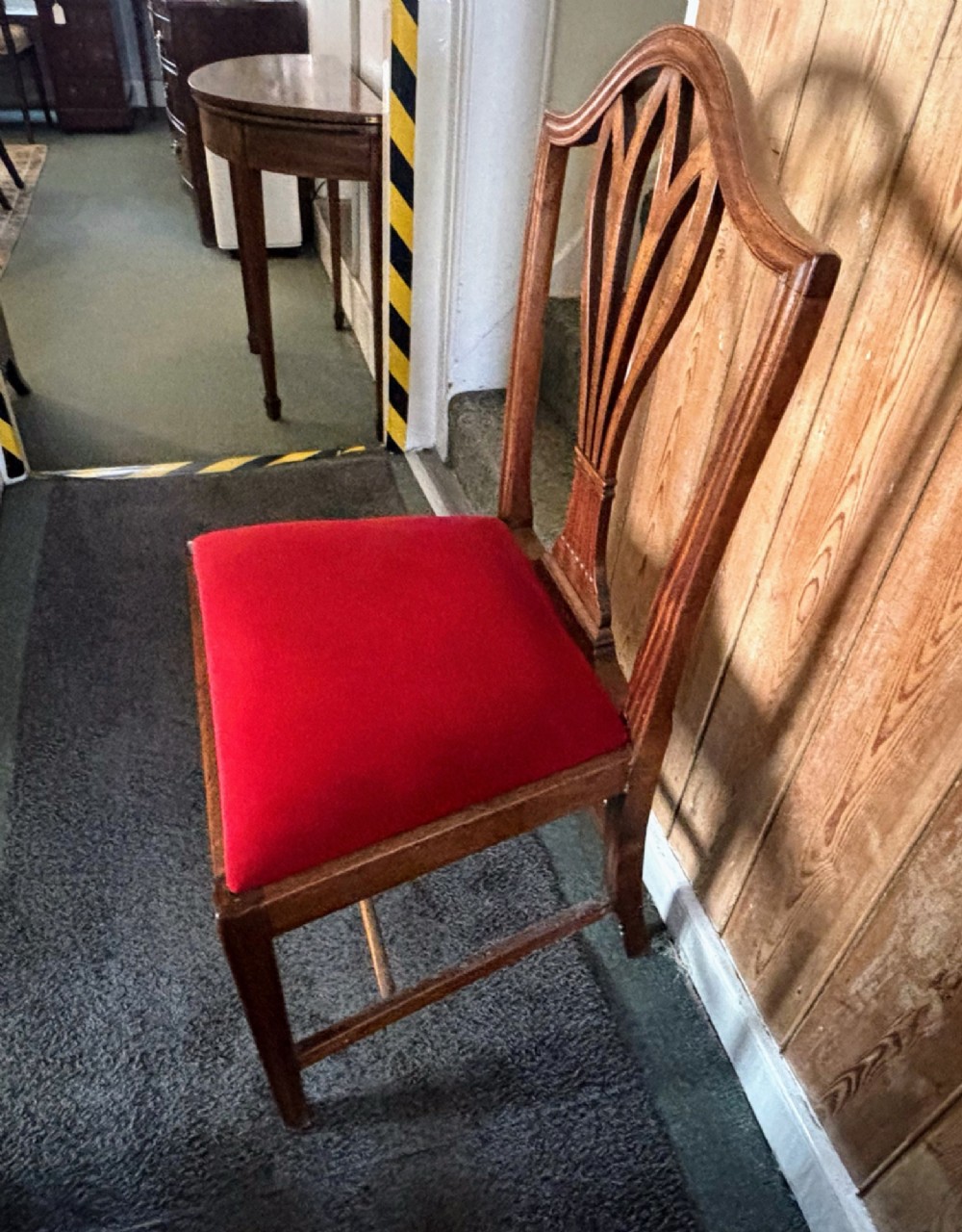 A set of eight George III mahogany dining chairs featuring carved wheat sheaf back splats and red velvet seats. View X