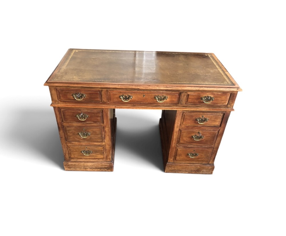 A Victorian walnut pedestal desk featuring nine drawers with brass handles and a gilt-tooled leather writing top. View II