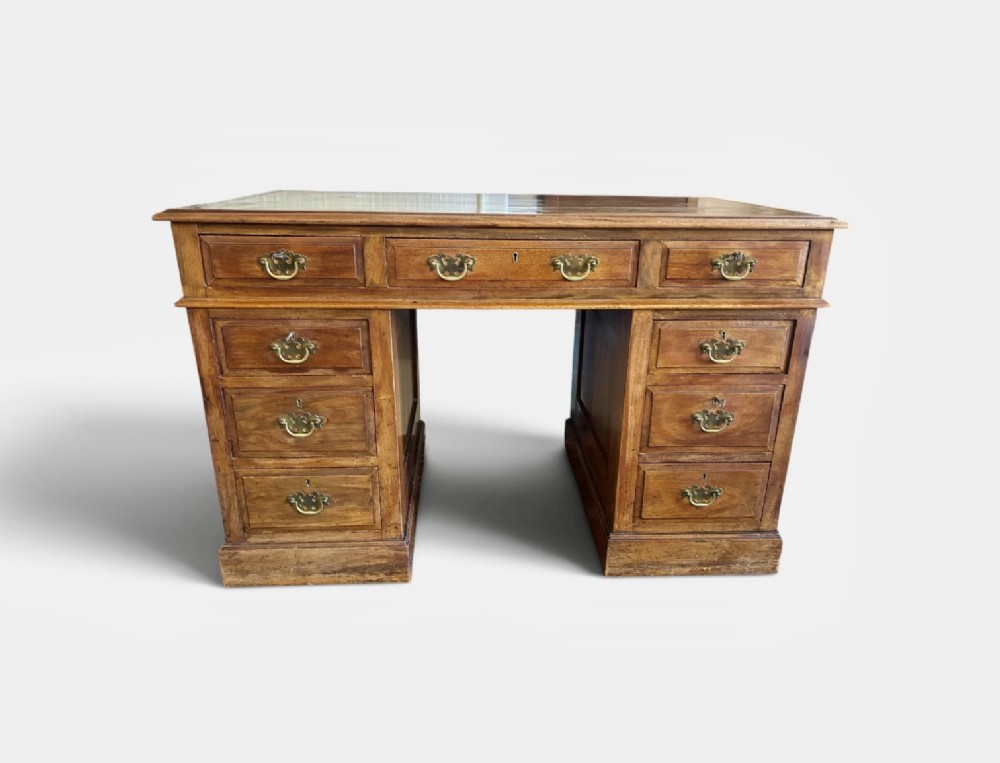 A Victorian walnut pedestal desk featuring nine drawers with brass handles and a gilt-tooled leather writing top. View III