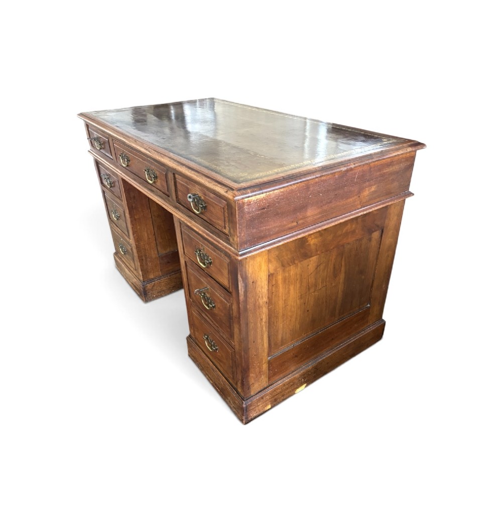 A Victorian walnut pedestal desk featuring nine drawers with brass handles and a gilt-tooled leather writing top. View IV