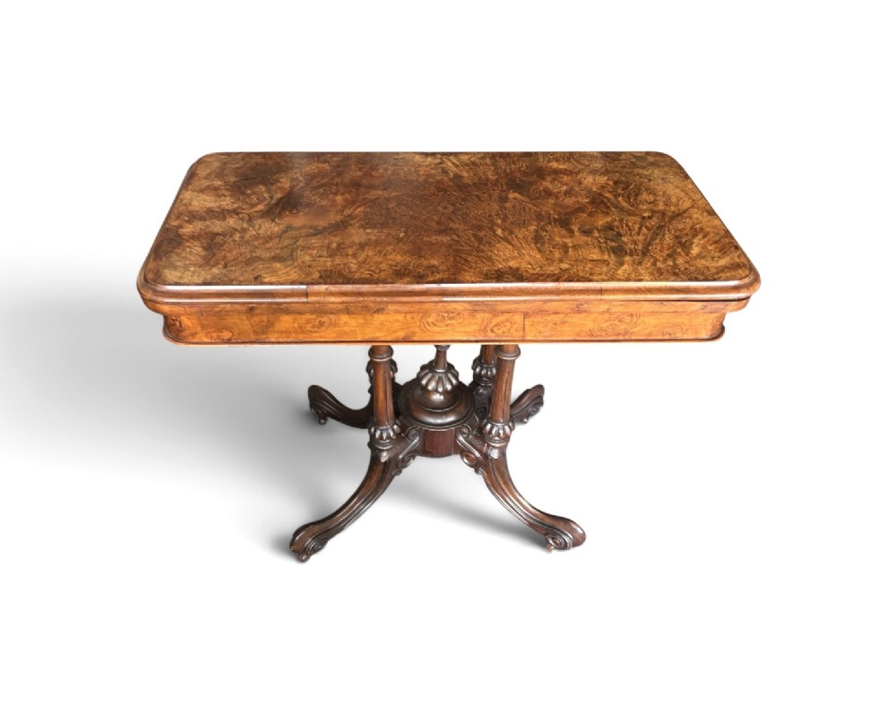 A Victorian rectangular flip-top card table made from figured walnut wood, featuring rounded corners and a carved quad-form pedestal base. View IV
