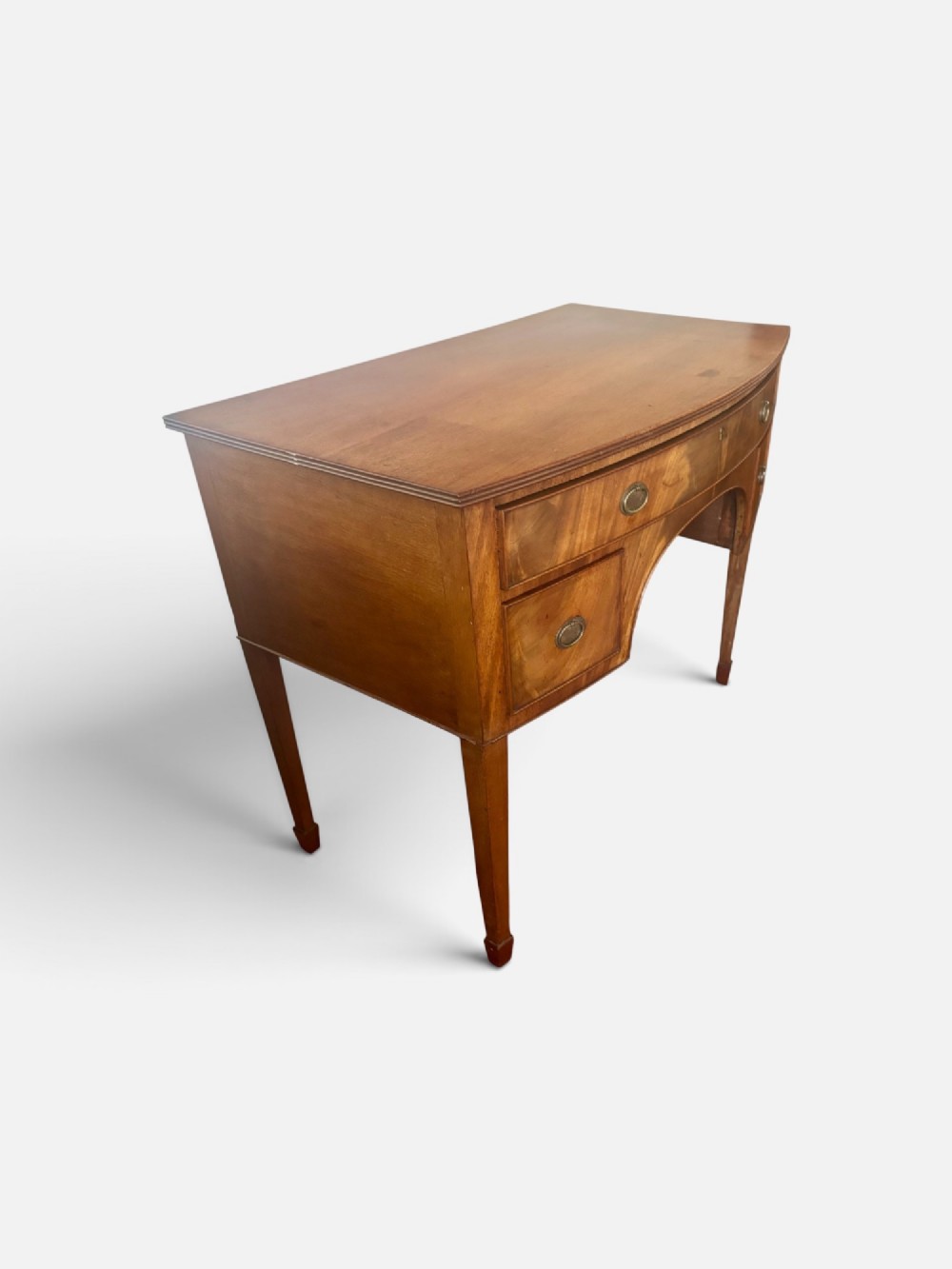 A Regency mahogany bow-front dressing table with a central arched kneehole, three drawers with oval brass handles, and square tapered legs. View II