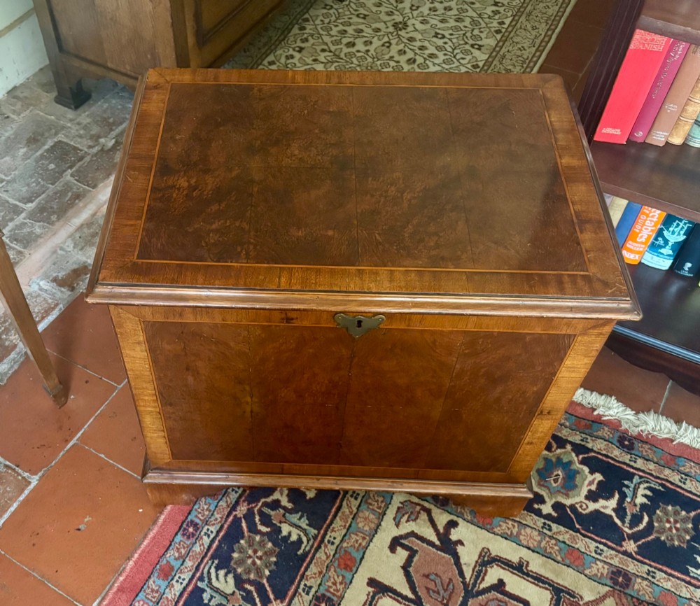 A small antique figured walnut coffer featuring crossbanded borders, a brass escutcheon, and bracket feet. View VI