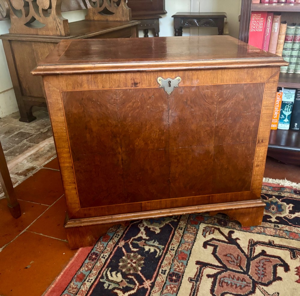 A small antique figured walnut coffer featuring crossbanded borders, a brass escutcheon, and bracket feet. View VII