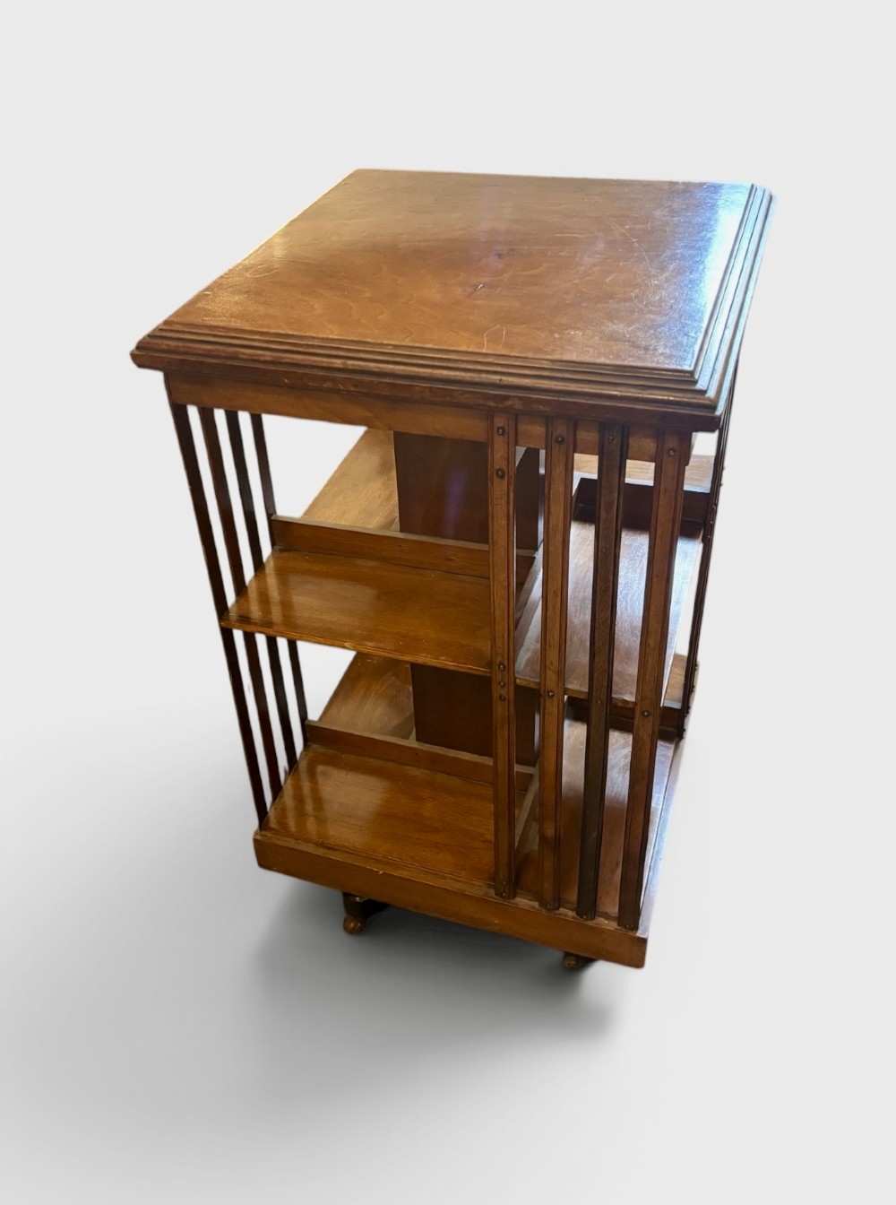 A square two-tier Edwardian revolving bookcase crafted from warm brown polished mahogany with vertical slatted sides. View II