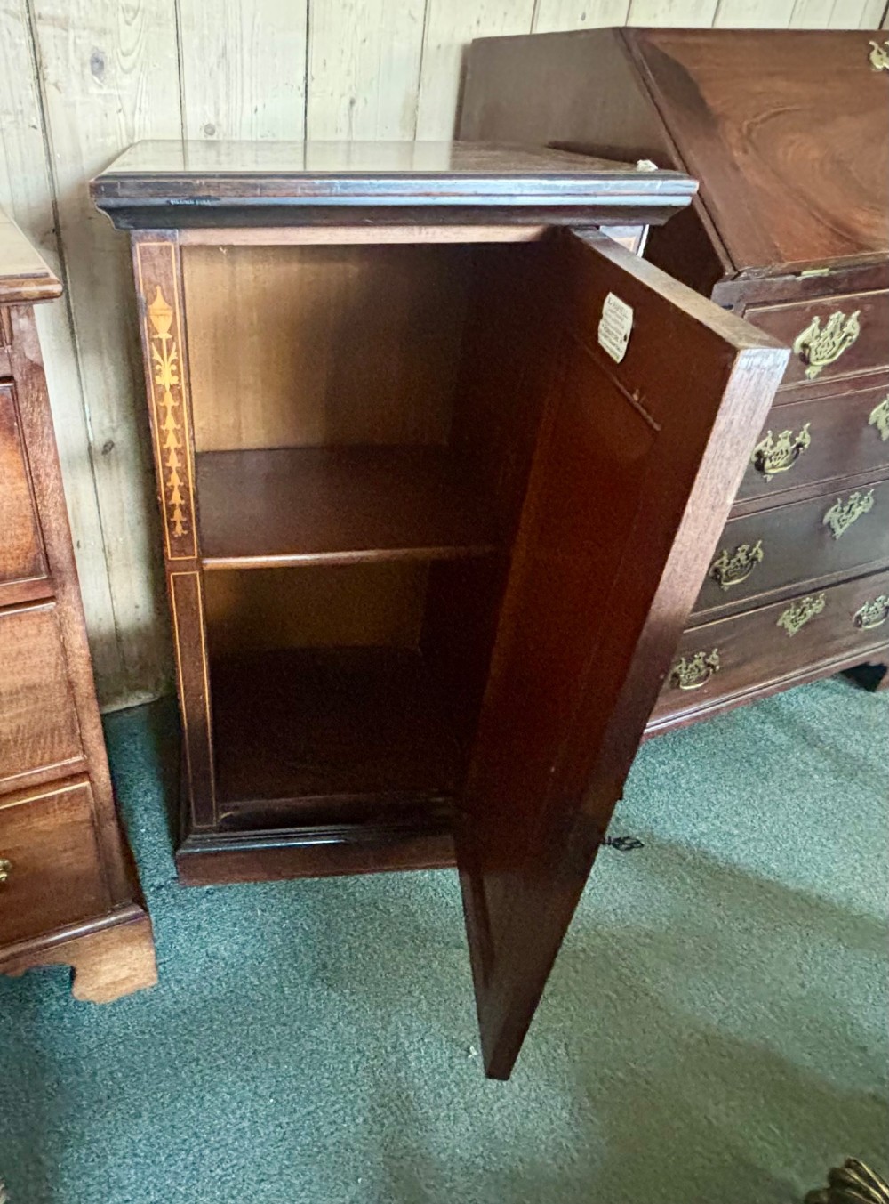 A narrow Victorian dark rosewood single-door cabinet featuring detailed satinwood floral and urn marquetry inlay. View VI