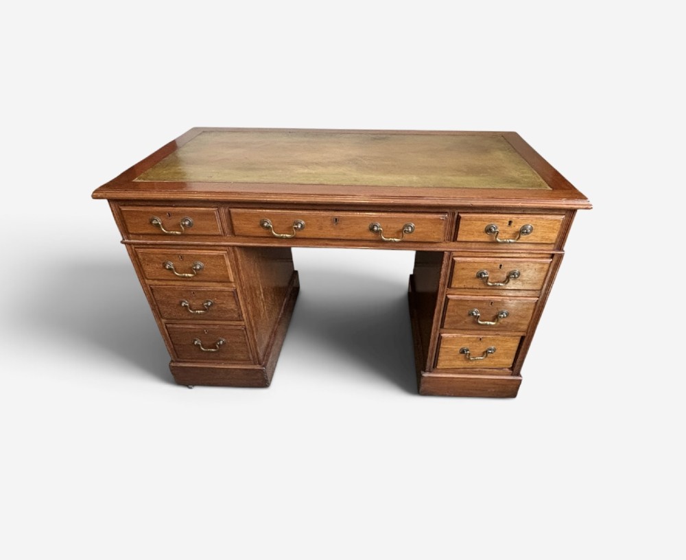 A Victorian mahogany pedestal desk featuring an inset green leather writing surface and nine drawers with brass drop handles. View II