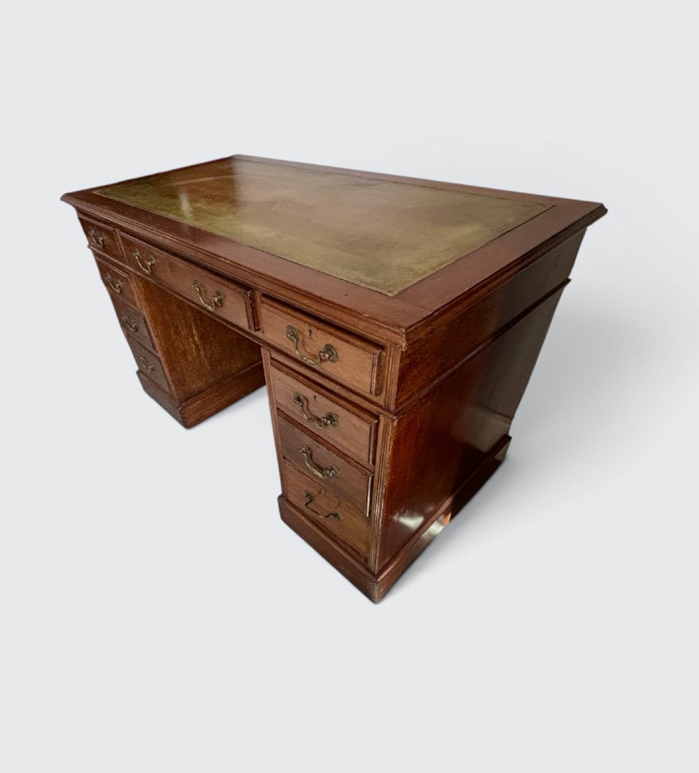 A Victorian mahogany pedestal desk featuring an inset green leather writing surface and nine drawers with brass drop handles. View V