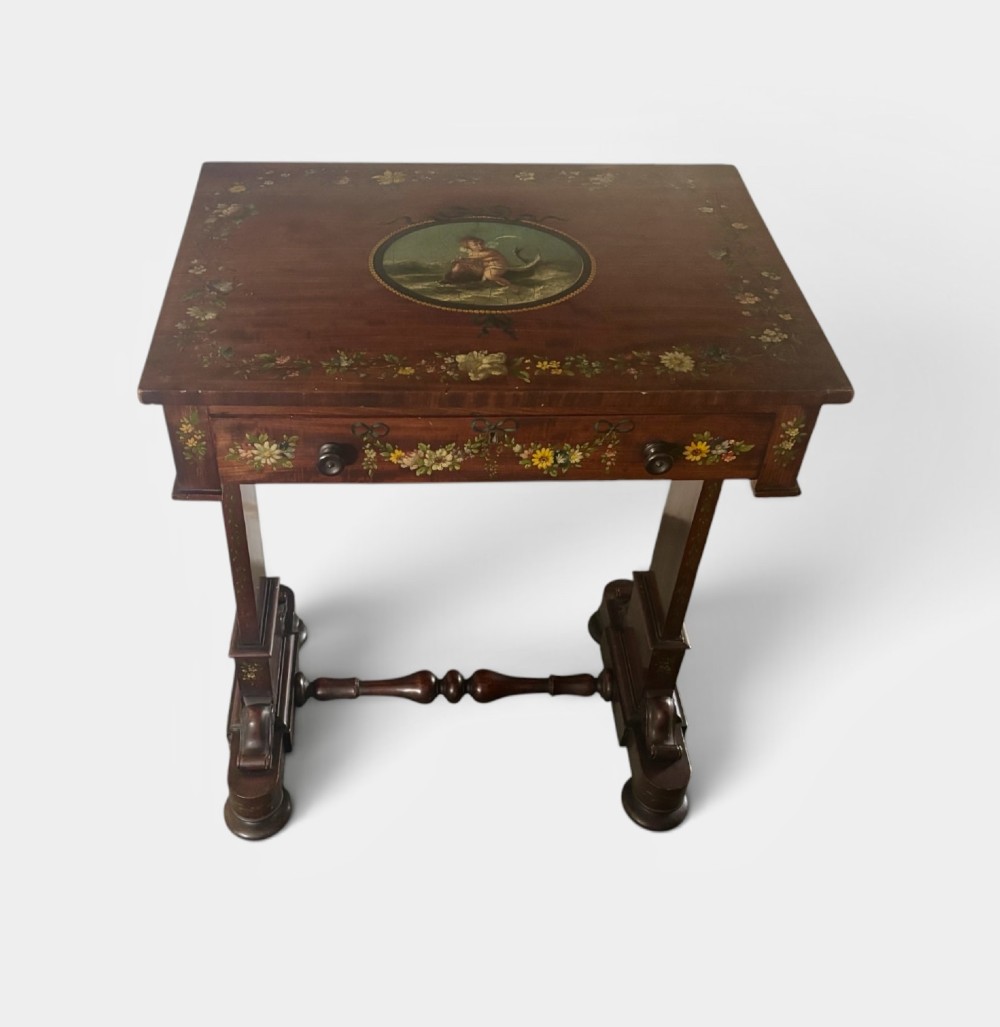 An early Victorian mahogany side table featuring hand-painted floral garlands across the surface and drawer, supported by trestle legs and a turned central stretcher. View III