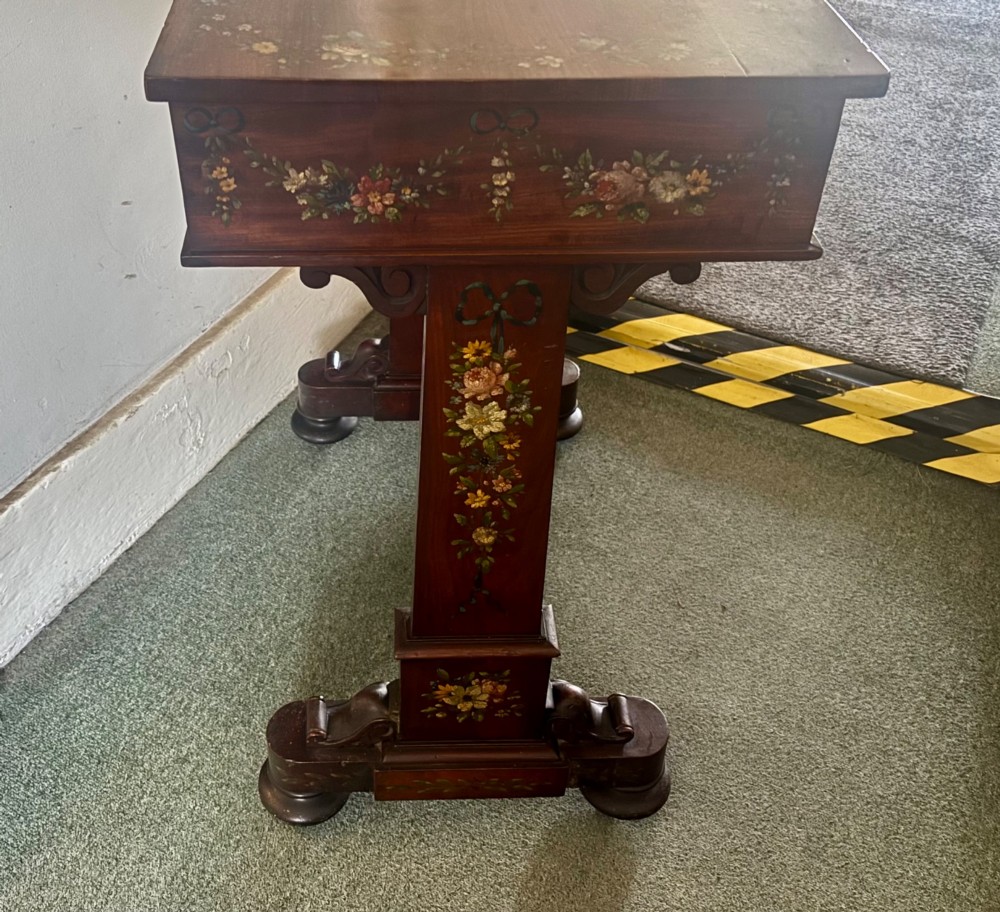 An early Victorian mahogany side table featuring hand-painted floral garlands across the surface and drawer, supported by trestle legs and a turned central stretcher. View IV