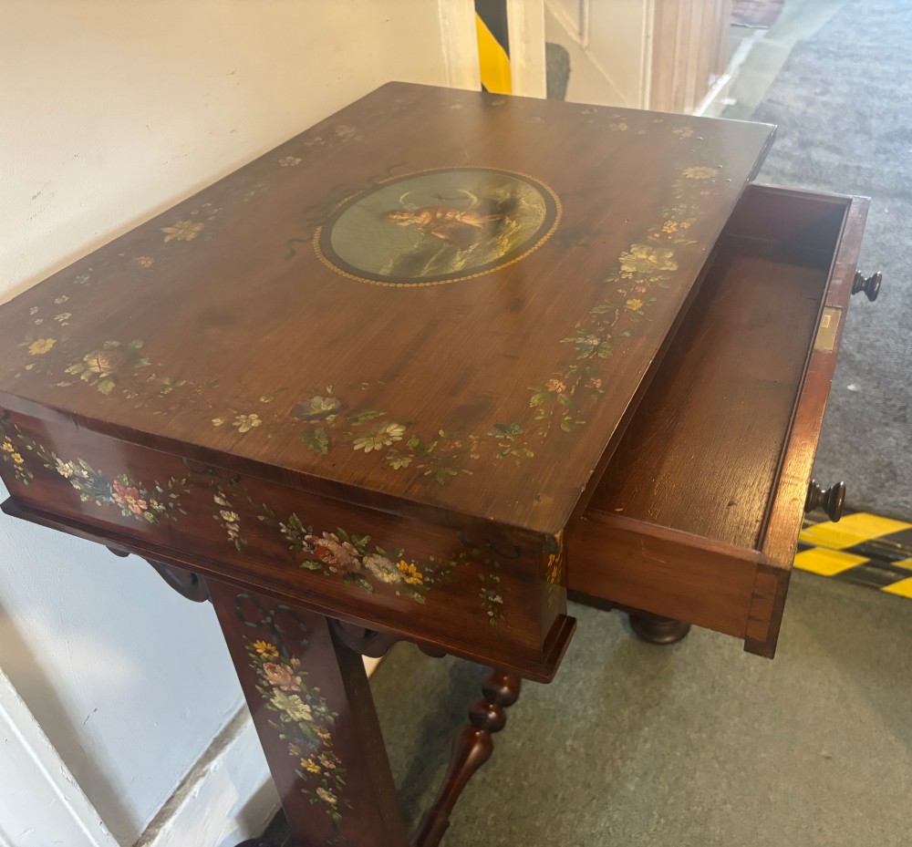 An early Victorian mahogany side table featuring hand-painted floral garlands across the surface and drawer, supported by trestle legs and a turned central stretcher. View VIII