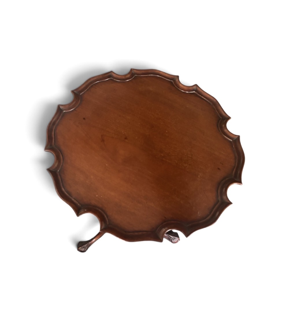 A small mahogany tripod table featuring a raised scalloped piecrust top supported by a carved central pedestal and three cabriole legs. View III
