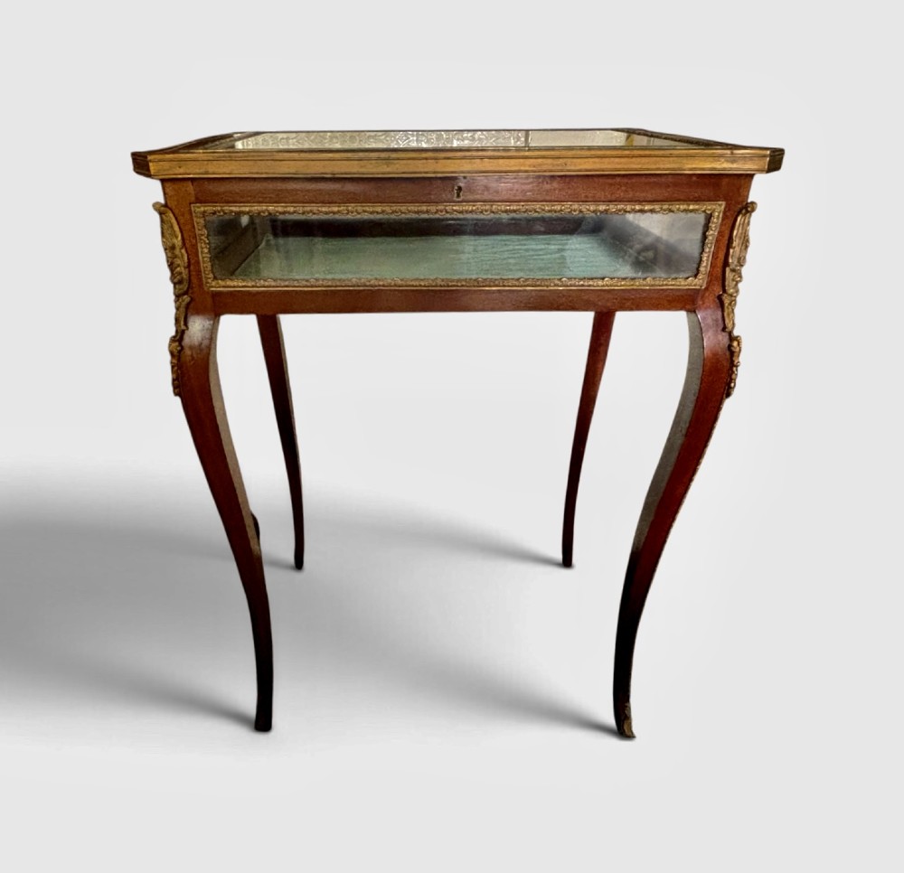 A 19th-century walnut vitrine display table featuring glass side panels, decorative metal mounts, and slender cabriole legs. View IV