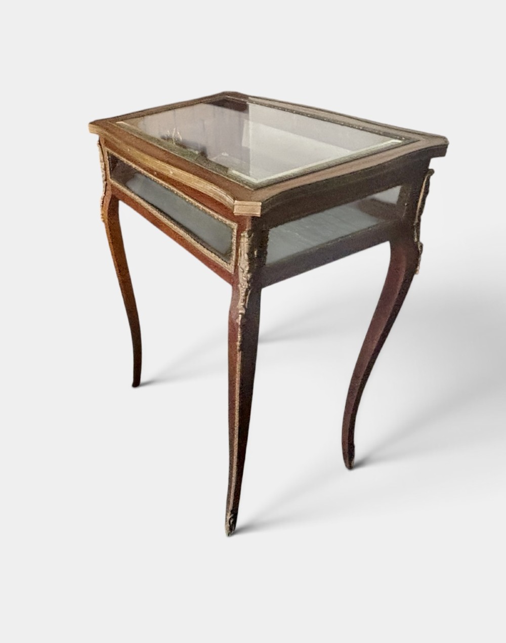 A 19th-century walnut vitrine display table featuring glass side panels, decorative metal mounts, and slender cabriole legs. View VII