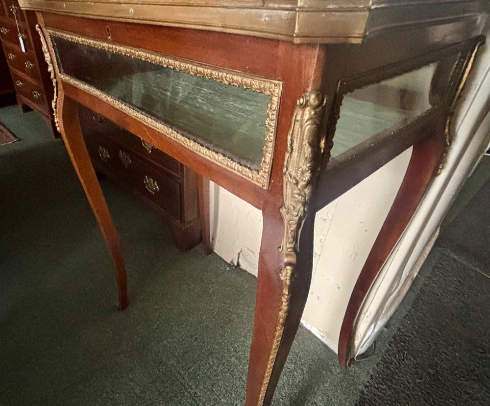 A 19th-century walnut vitrine display table featuring glass side panels, decorative metal mounts, and slender cabriole legs. View IX