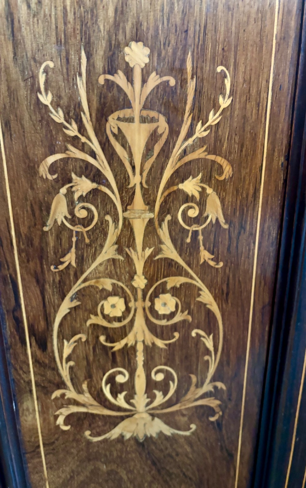 A tall, narrow Victorian rosewood cabinet featuring intricate floral marquetry inlay on the single panelled door and side pilasters. View II