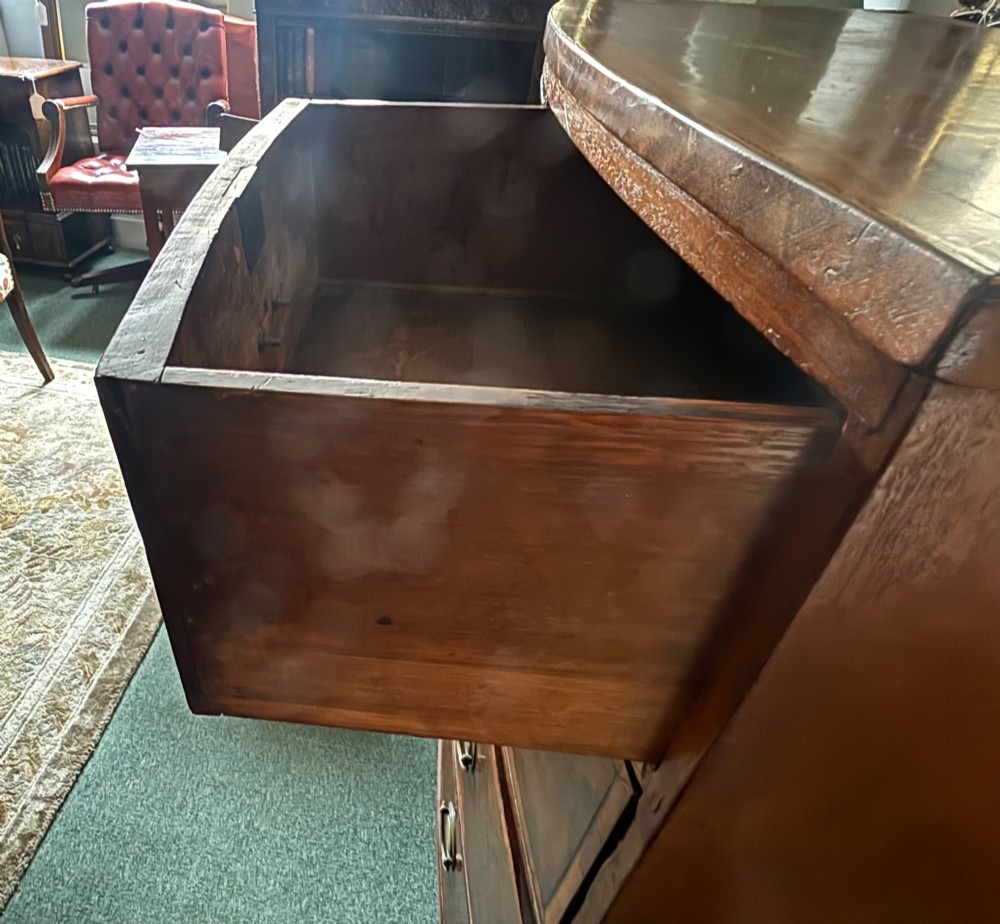 A Regency mahogany bowfront chest of drawers featuring two short over three long graduated drawers with satinwood crossbanding and brass oval plate handles. View V