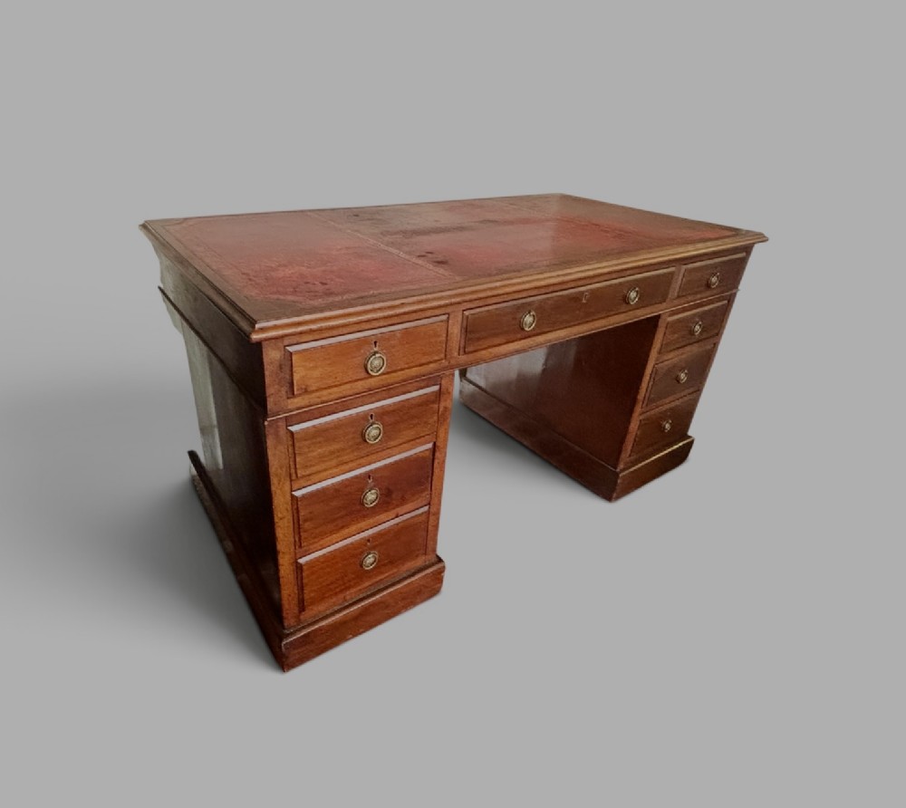 A large Edwardian mahogany pedestal desk featuring nine drawers with circular brass ring handles and a flat plinth base. View III
