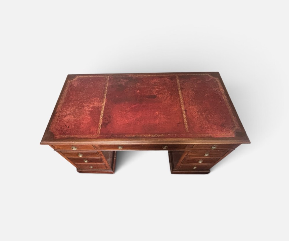 A large Edwardian mahogany pedestal desk featuring nine drawers with circular brass ring handles and a flat plinth base. View IV
