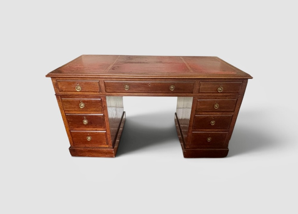 A large Edwardian mahogany pedestal desk featuring nine drawers with circular brass ring handles and a flat plinth base. View V