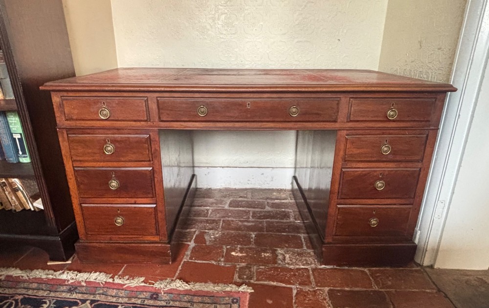 A large Edwardian mahogany pedestal desk featuring nine drawers with circular brass ring handles and a flat plinth base. View IX