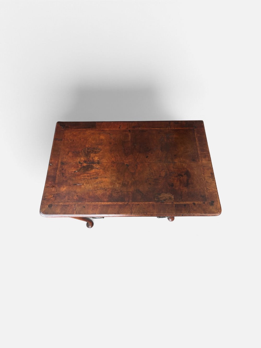 A George III walnut lowboy featuring a crossbanded top, a drawer with brass handles, and slender cabriole legs terminating in pad feet. View III