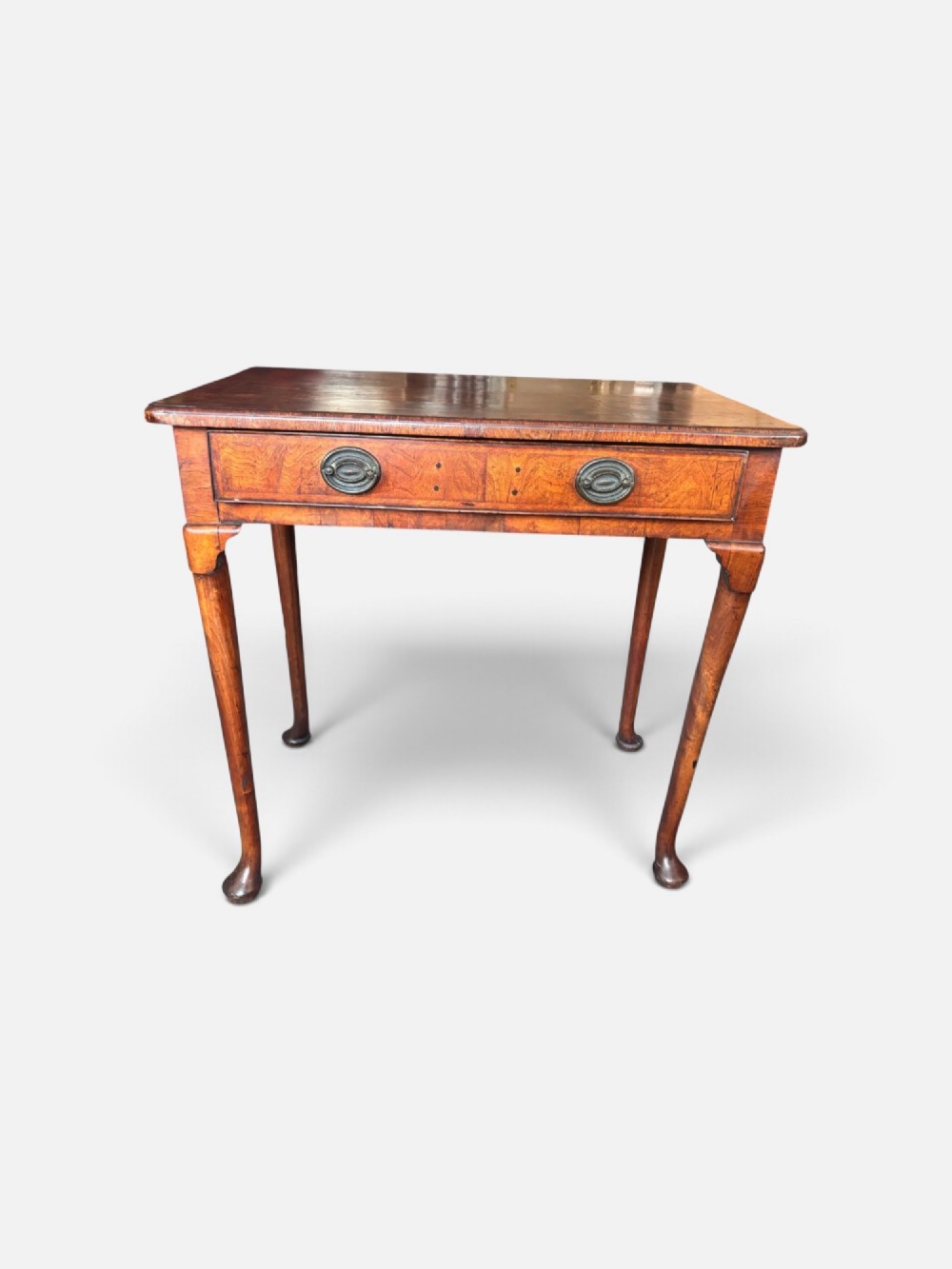 A George III walnut lowboy featuring a crossbanded top, a drawer with brass handles, and slender cabriole legs terminating in pad feet. View IV