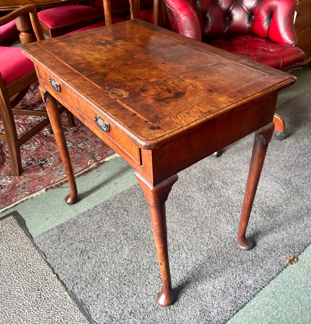 A George III walnut lowboy featuring a crossbanded top, a drawer with brass handles, and slender cabriole legs terminating in pad feet. View VI