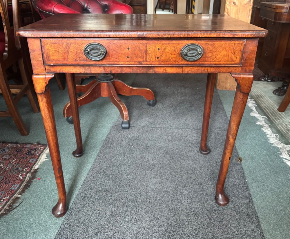A George III walnut lowboy featuring a crossbanded top, a drawer with brass handles, and slender cabriole legs terminating in pad feet. View IX