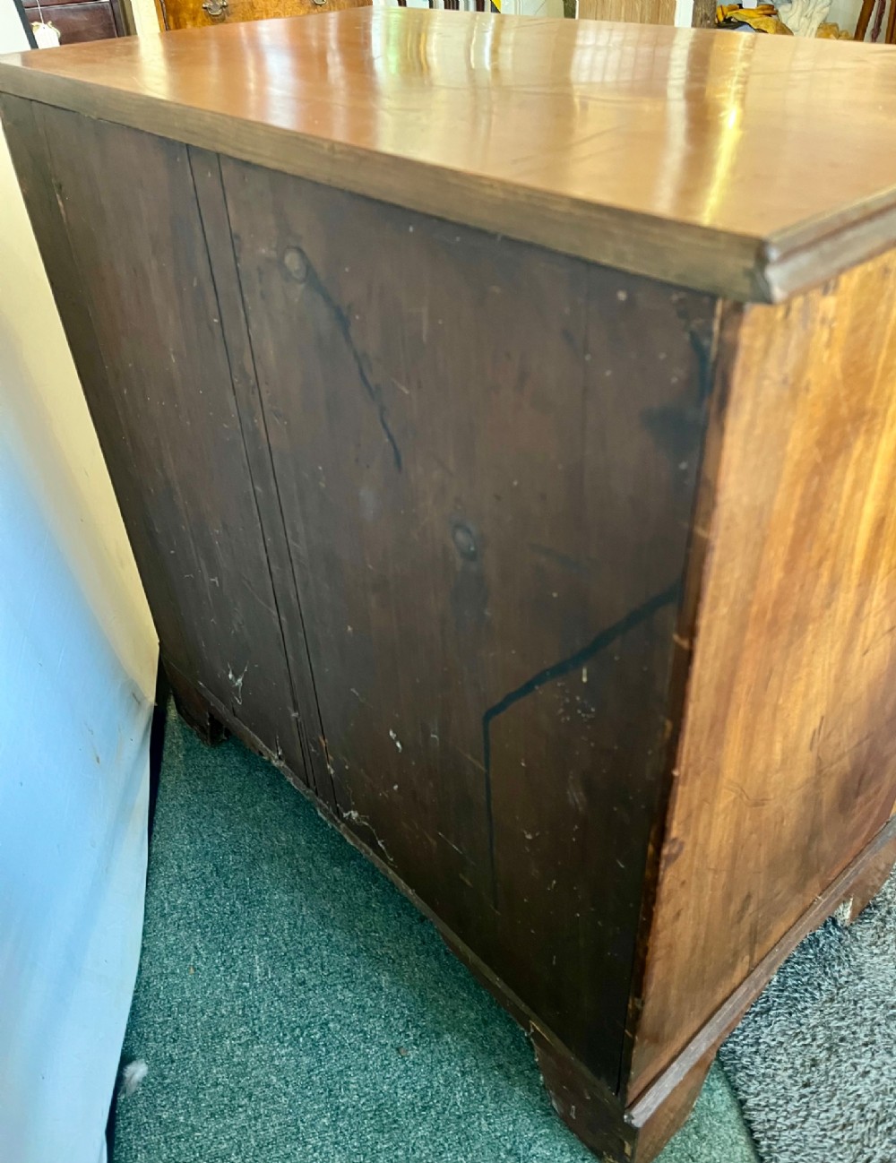 An Edwardian mahogany chest of drawers with two short drawers over three long drawers, brass swan-neck handles, and bracket feet. View IX
