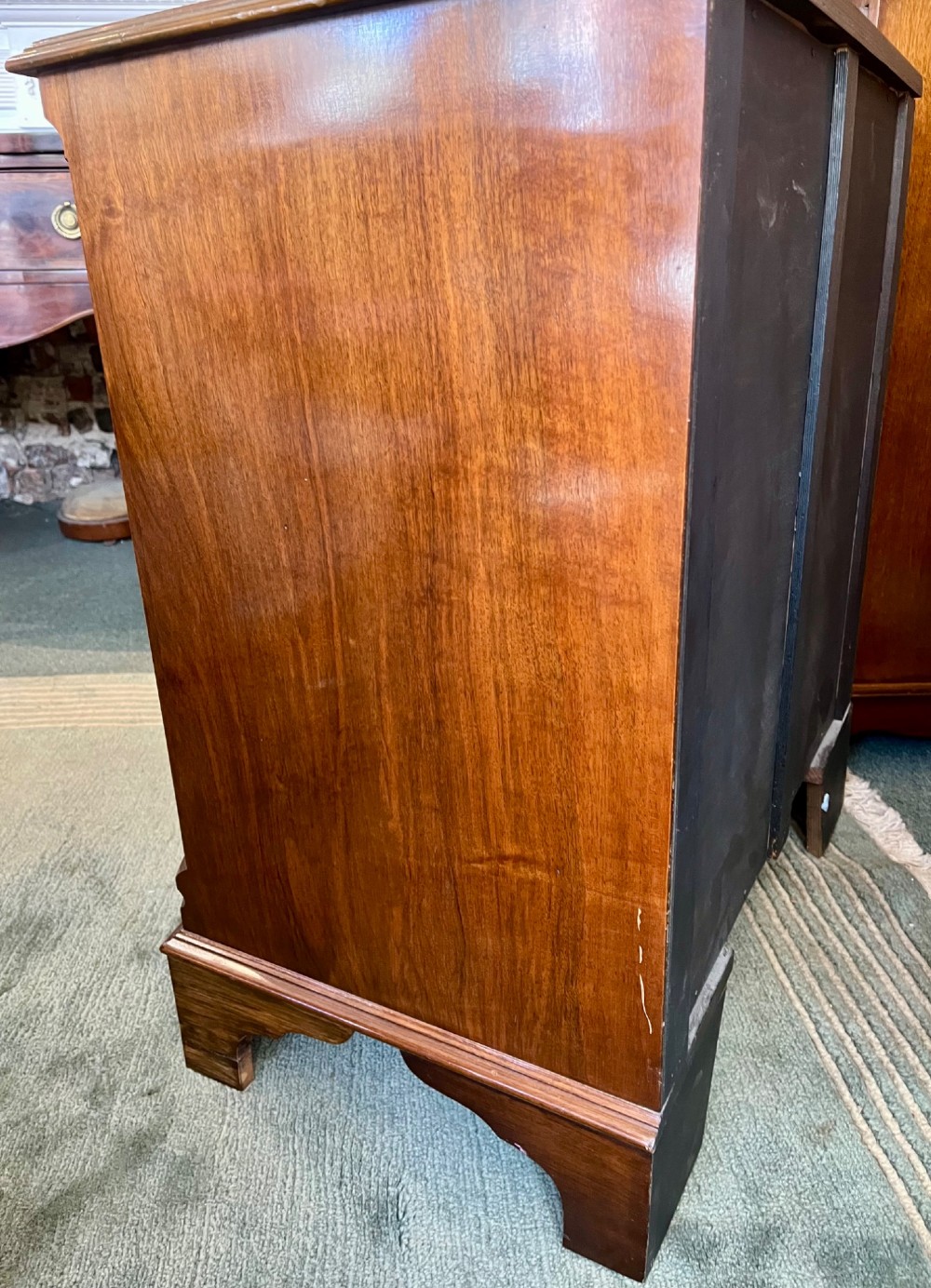 A burr walnut bow-front chest of four graduated drawers featuring brass drop handles, herringbone crossbanding, and bracket feet. View IX
