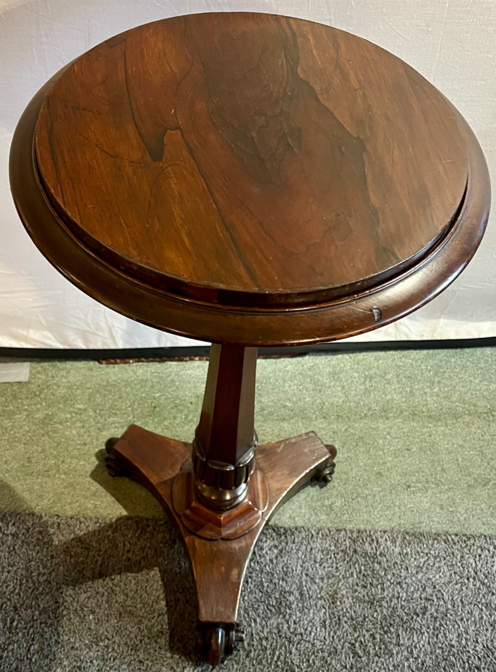 An early 19th-century rosewood wine table featuring a circular top, a tapered column, and a triform base with carved feet. View II