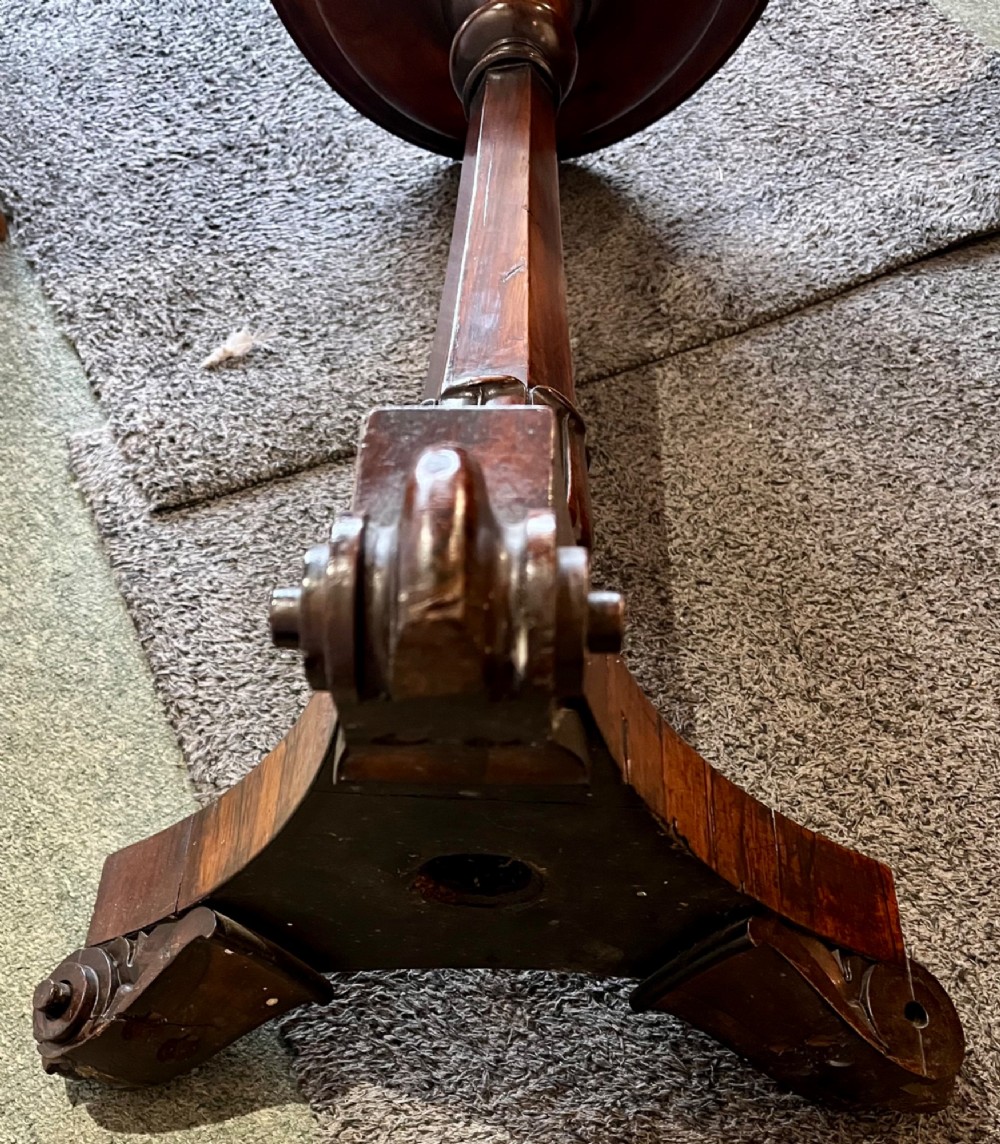 An early 19th-century rosewood wine table featuring a circular top, a tapered column, and a triform base with carved feet. View VII