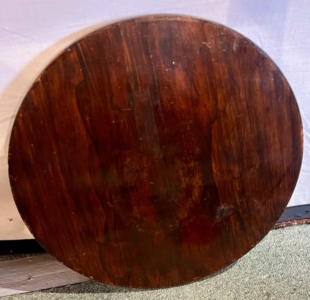 An early 19th-century rosewood wine table featuring a circular top, a tapered column, and a triform base with carved feet. View IX