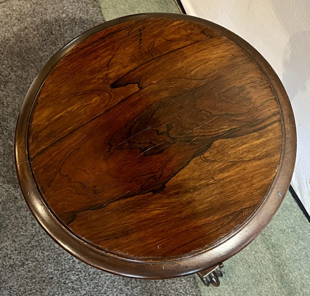 An early 19th-century rosewood wine table featuring a circular top, a tapered column, and a triform base with carved feet. View XI