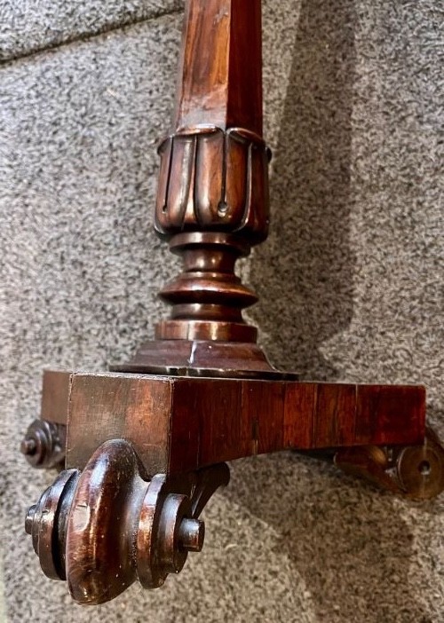 An early 19th-century rosewood wine table featuring a circular top, a tapered column, and a triform base with carved feet. View VI