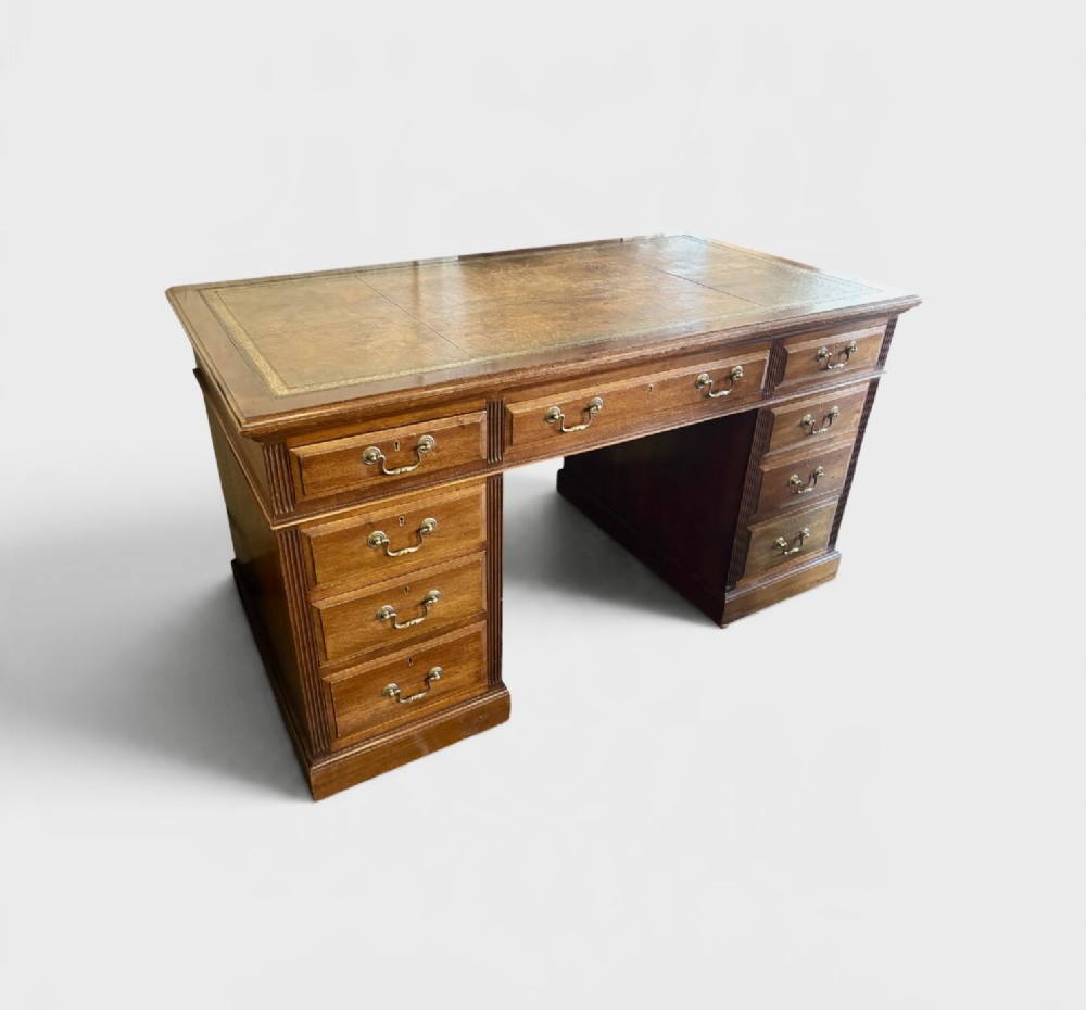 A Victorian mahogany pedestal desk featuring nine drawers with brass swan-neck handles and fluted side columns. View II