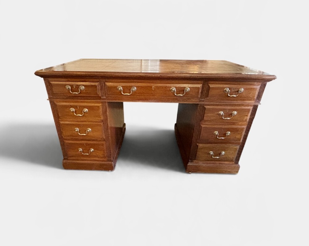 A Victorian mahogany pedestal desk featuring nine drawers with brass swan-neck handles and fluted side columns. View III