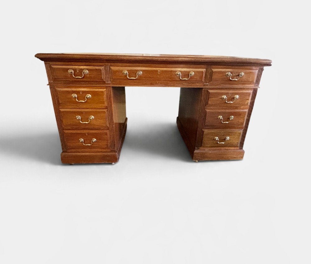 A Victorian mahogany pedestal desk featuring nine drawers with brass swan-neck handles and fluted side columns. View VI