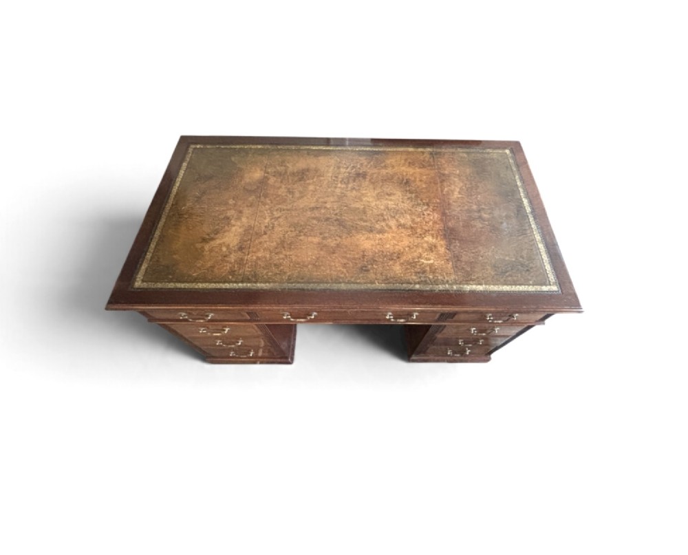 A Victorian mahogany pedestal desk featuring nine drawers with brass swan-neck handles and fluted side columns. View VII