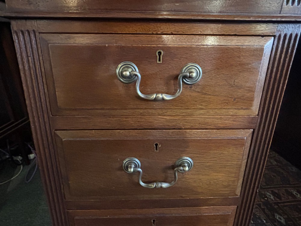 A Victorian mahogany pedestal desk featuring nine drawers with brass swan-neck handles and fluted side columns. View IX