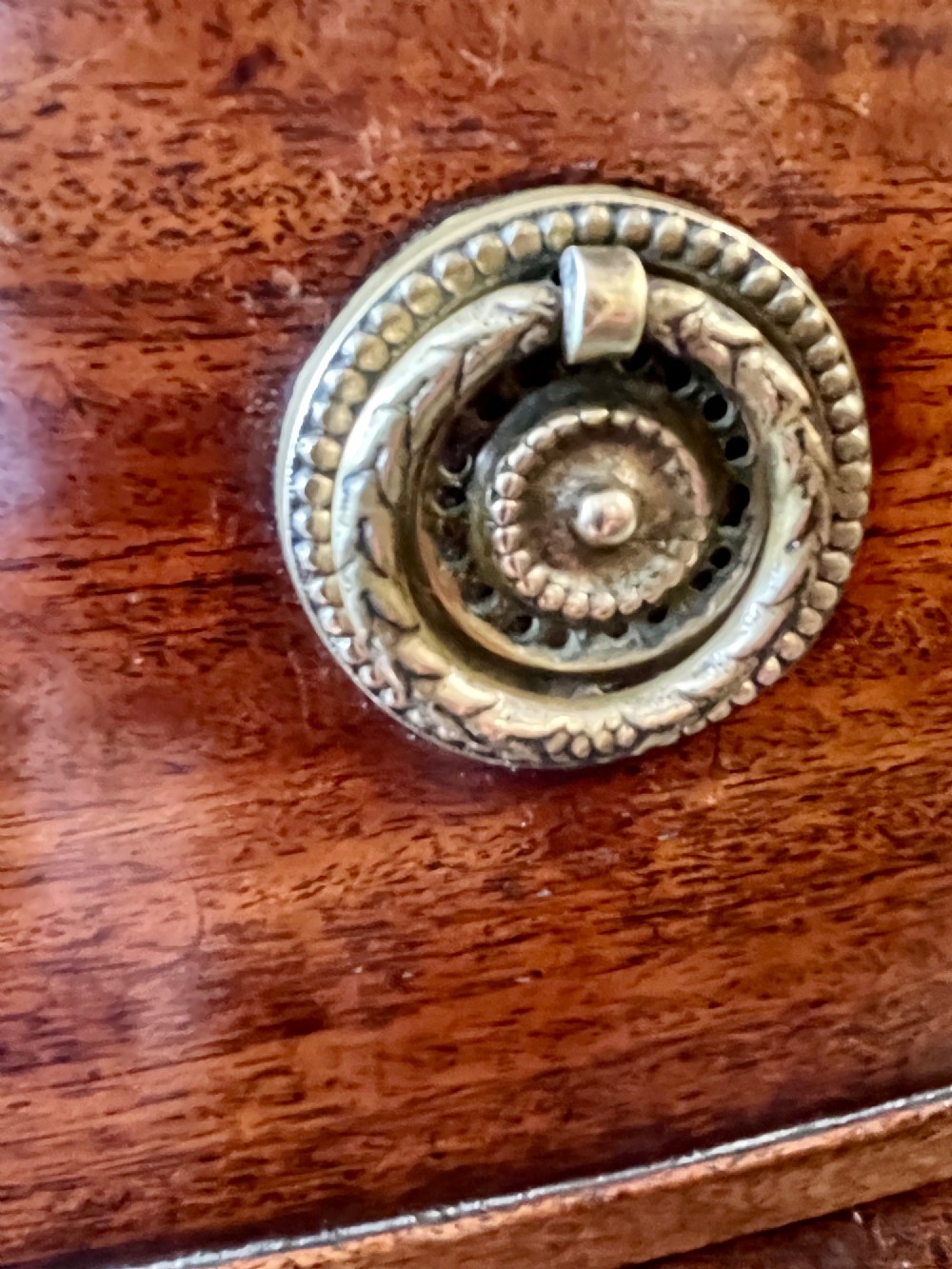A Regency mahogany bowfront chest featuring three graduated drawers with crossbanded top inlay and brass ring handles. View VII
