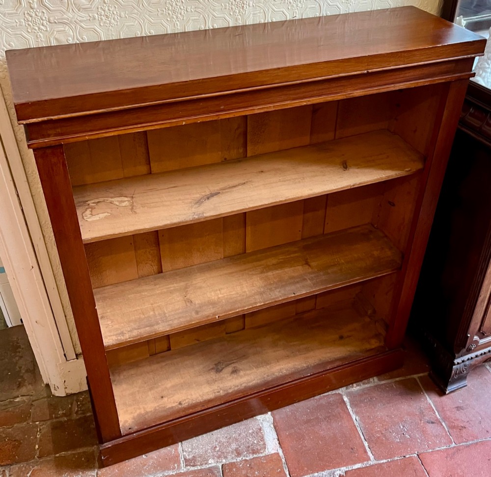 A Victorian open mahogany bookcase featuring three open timber shelves, a simple moulded top, and a plinth base.