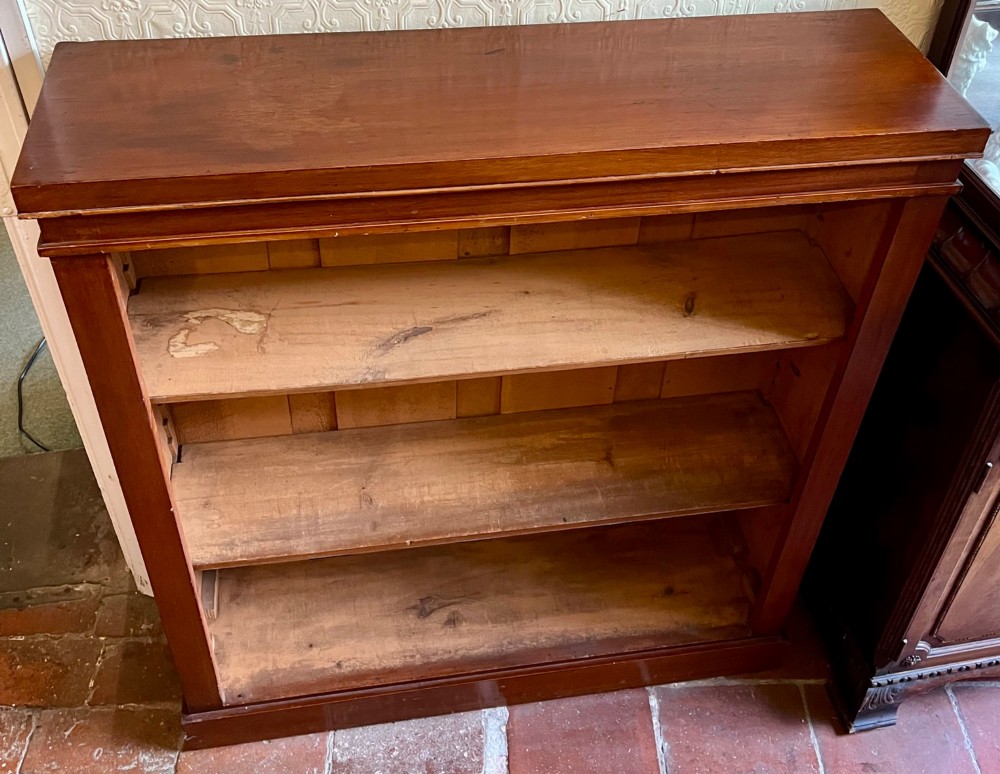 A Victorian open mahogany bookcase featuring three open timber shelves, a simple moulded top, and a plinth base. View II