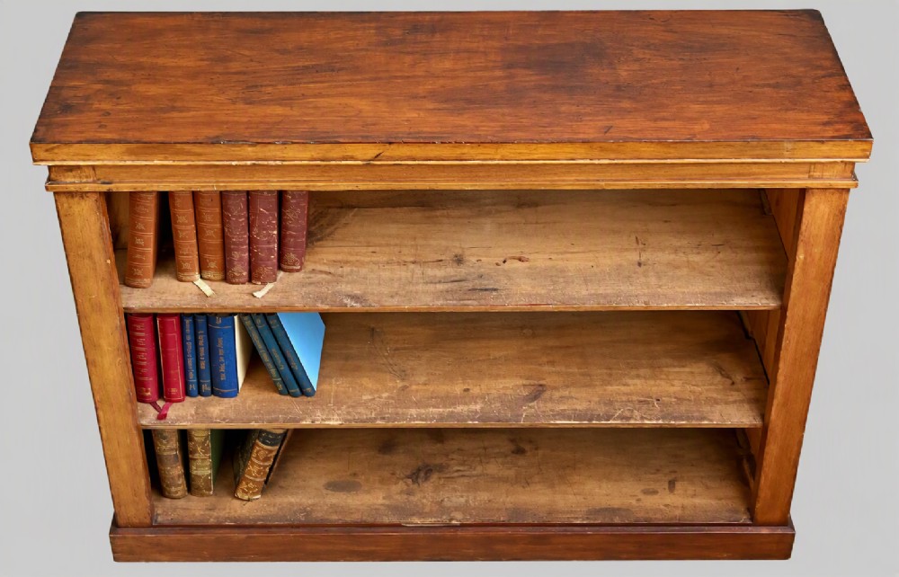 A low Victorian open mahogany bookcase featuring three wide shelves, exposed vertical backboards, a top edge, and a plinth base. View II